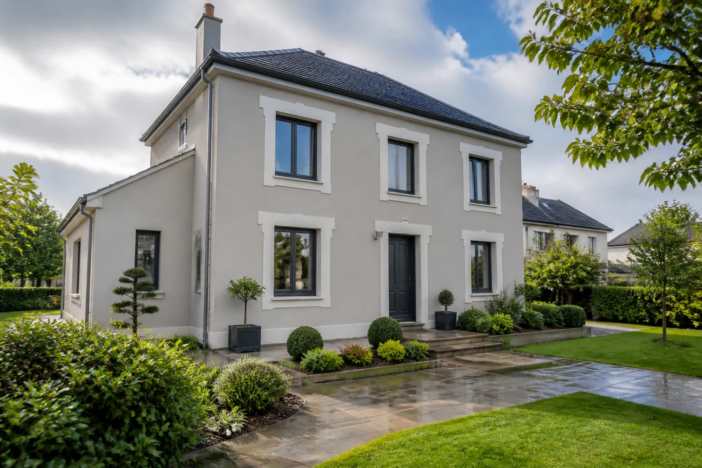 Résultat architectural d’une isolation par l’extérieur Maison rénovée associant enduit clair et accent de bardage bois